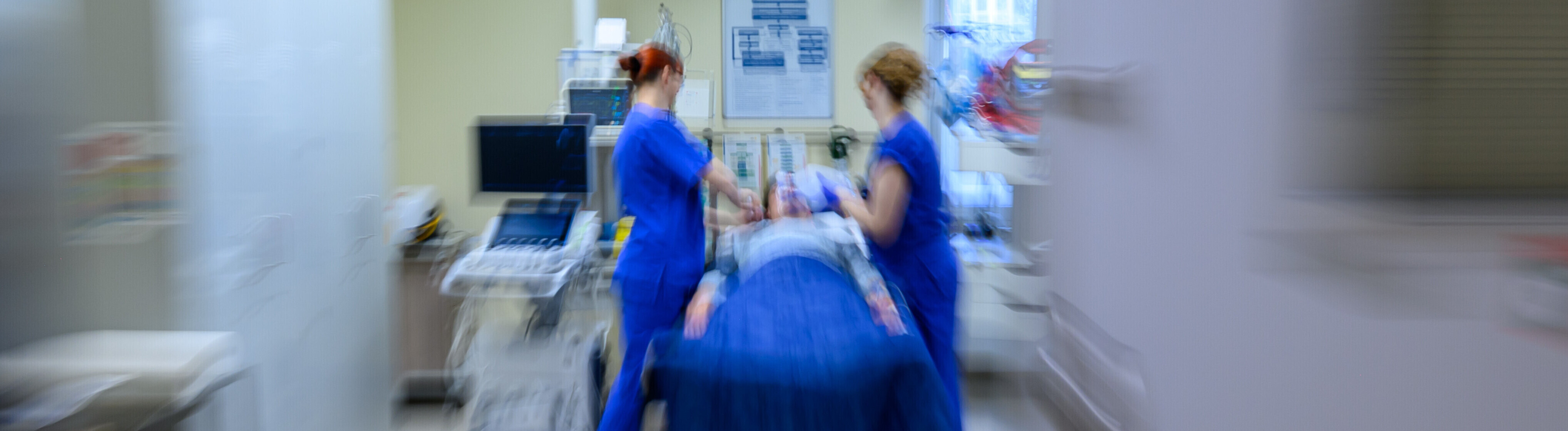 Medizinisches Personal behandelt eine liegende Person im Schockraum (Aufnahme mit Zoomeffekt)