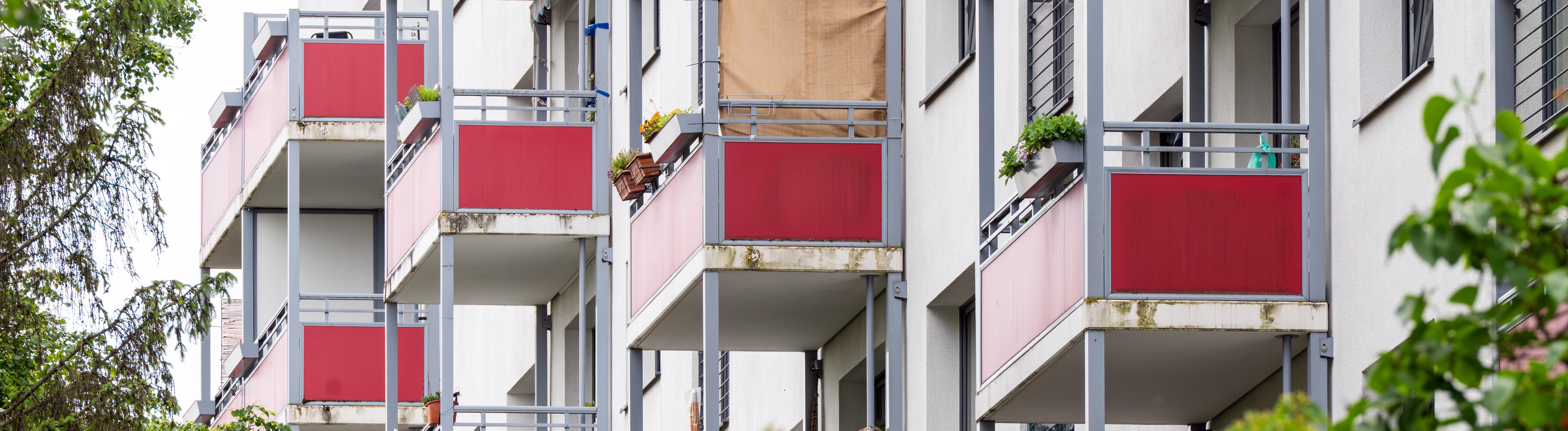 Rot verkleidete Balkons an einem Mehrfamilienhaus (Berlin, 03.06.2026)