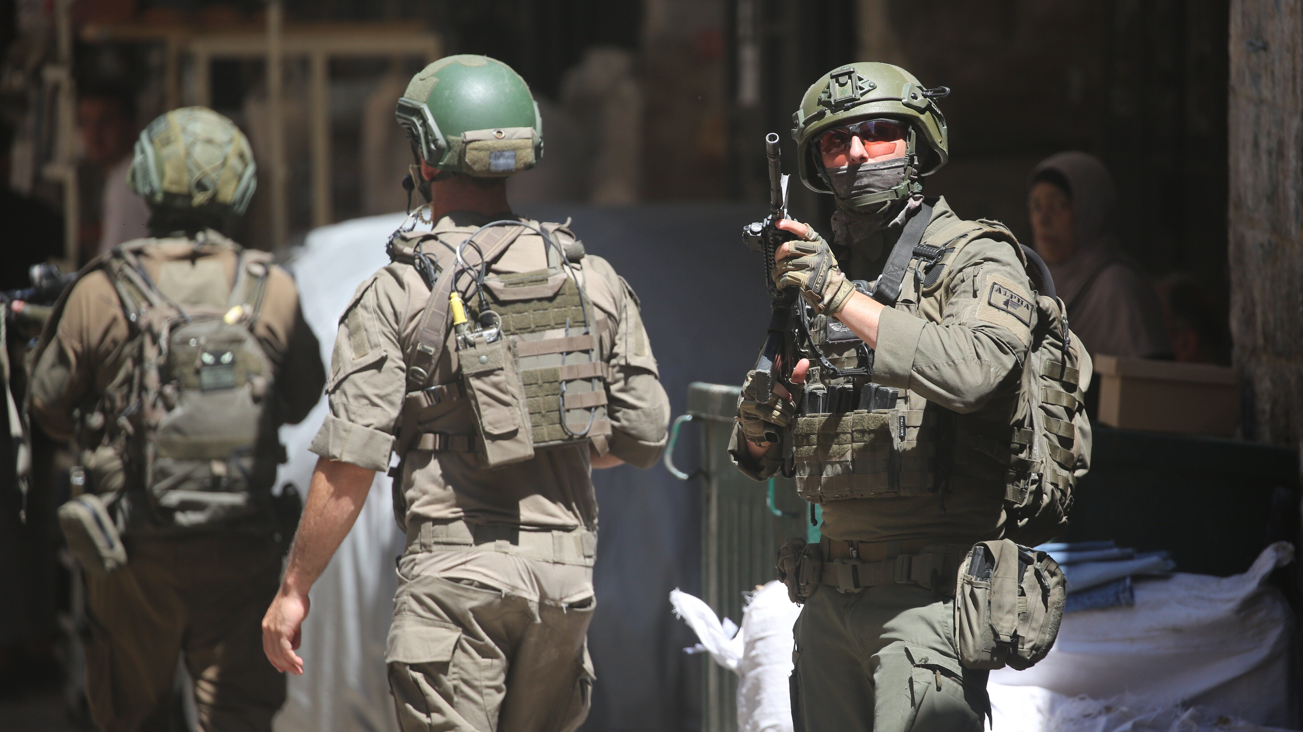 Drei israelische Soldaten patrouillieren auf einem Markt in der Altstadt von Nablus im nördlichen besetzten Westjordanland. Ein Soldat (r.) hält seine Waffe am Anschlag (23.06.2026)