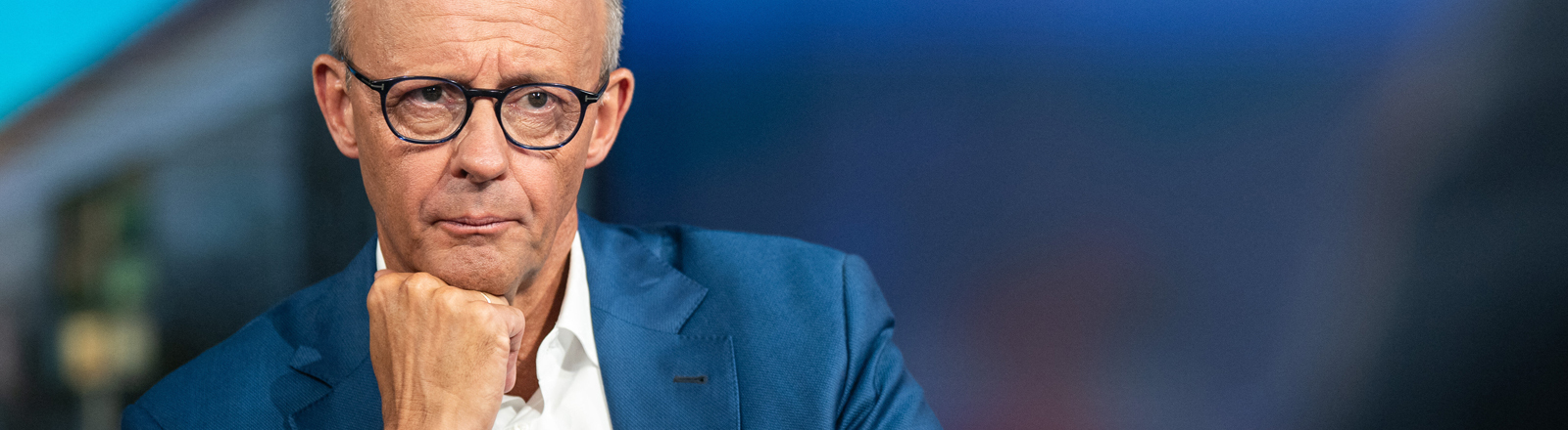 Bundeskanzler Friedrich Merz in einem TV-Studio mit Wasserglas