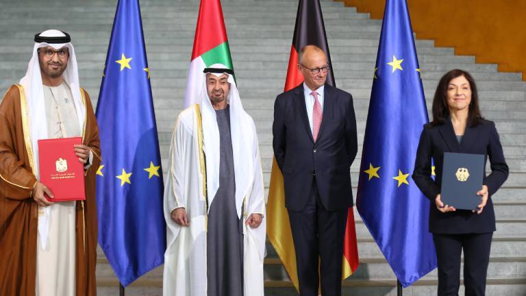 Offizielles Foto zum Staatsbesuch im Bundeskanzleramt. Bundeskanzler Friedrich Merz (Mitte rechts, im Anzug) empfängt Scheich Mohammed bin Zayed Al Nahyan, den Präsidenten und Herrscher der Vereinigten Arabischen Emirate (VAE) (Mitte links, in traditioneller weiß-grauer Kleidung). Flankiert werden die beiden von Delegationsmitgliedern vor den Flaggen der EU, der VAE und Deutschlands.