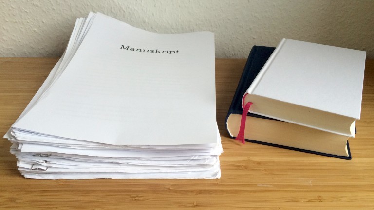 Das undatierte Foto zeigt einen Stapel Blätter und Bücher, aufgenommen in Berlin. Bis aus einer Geschichte ein Buch wird, dauert es eine Weile. Dabei helfen oft auch Literatur-Agenten.