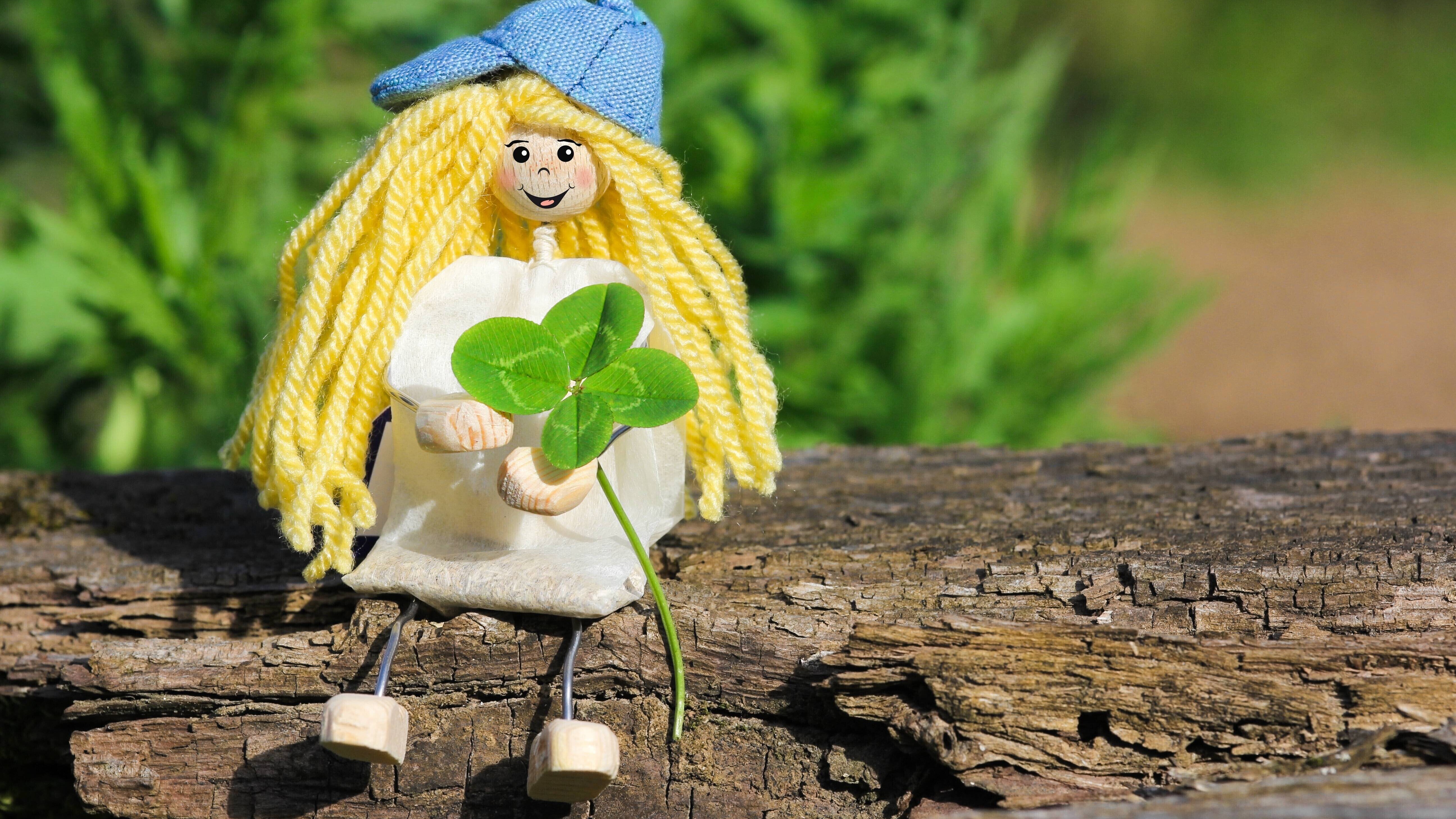 Puppe mit Kleeblatt auf einem Ast