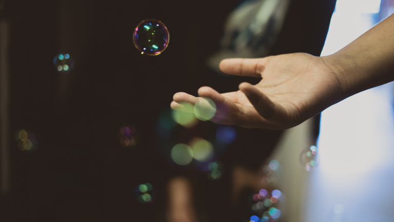 Frau hält Hand in Seifenblasen