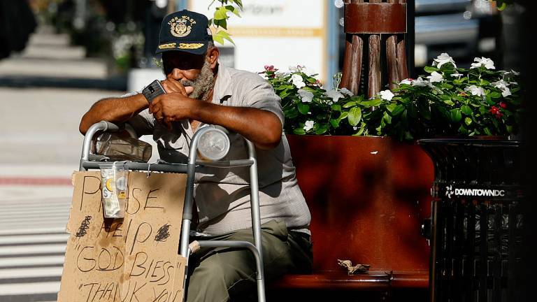Obdachloser Mensch sitzt mit Schild mit Bitte um Geld auf den Straßen von Washington, USA
