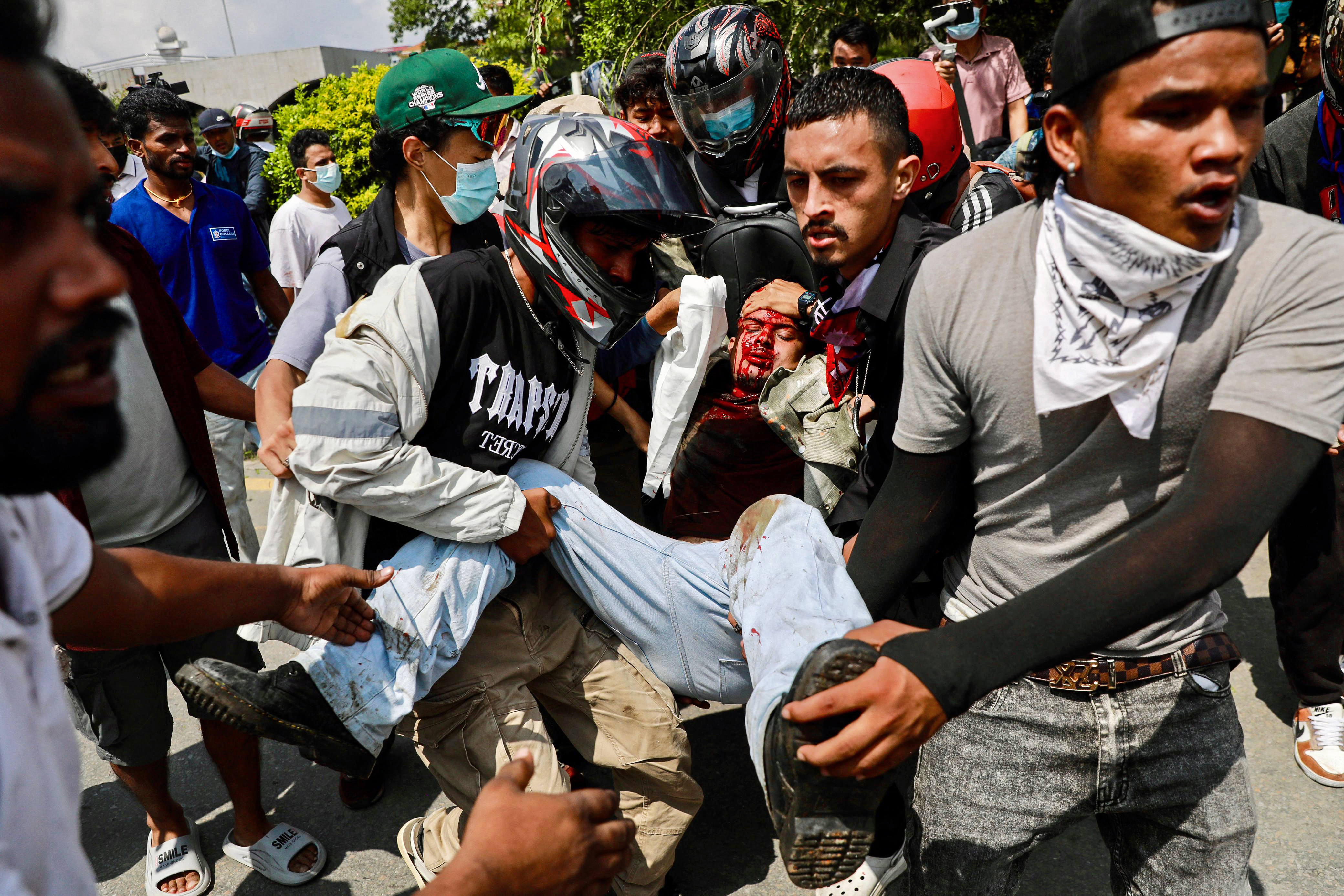 Demonstranten tragen einen Verletzten vor dem Parlament in Kathmandu, Nepal (8.09.2025)