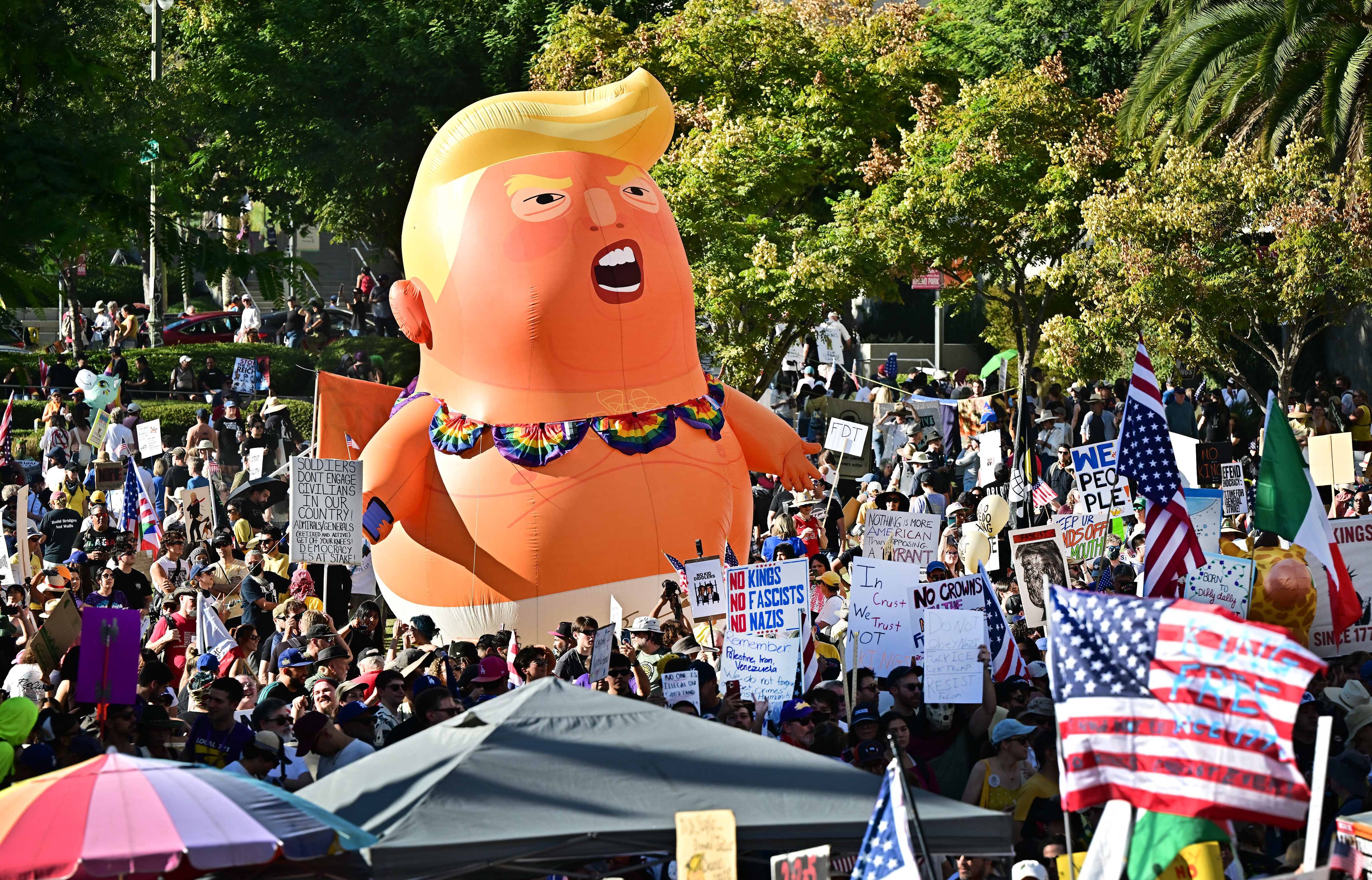 Eine No-Kings-Demonstration mit Plakaten und einer großen aufblasbaren Puppe in Form von Donald Trump