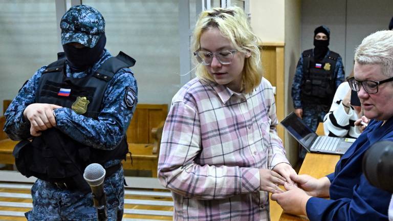 Diana Loginowa vor Gericht in St. Petersburg, neben ihr steht ein vermummter russischer Polizist  (11.11.2025)