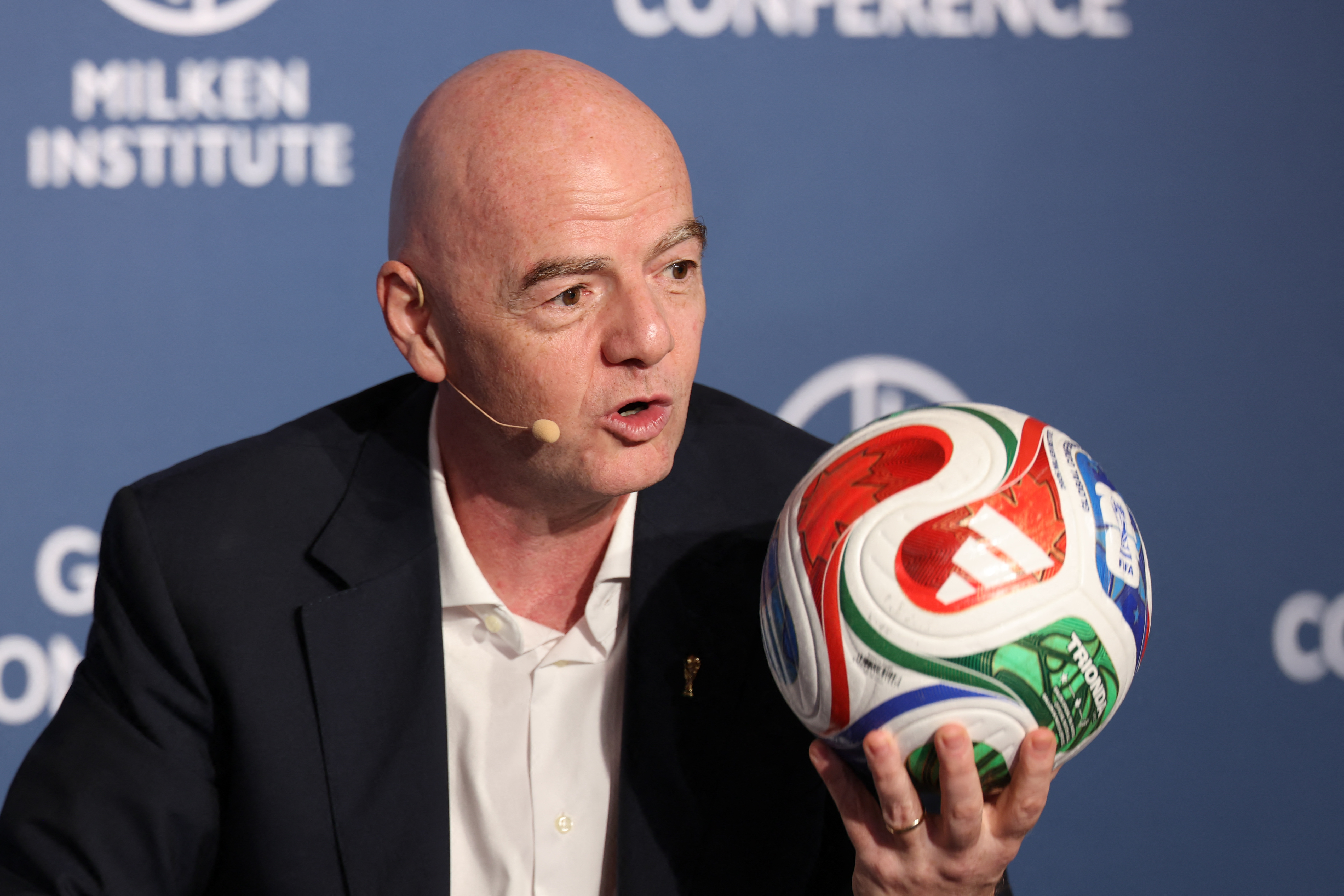 FIFA-Präsident Gianni Infantino hält während der 29. jährlichen Milken Institute Global Conference einen bunten Fußball hoch (Beverly Hills, Kalifornien, 5.05.2026)