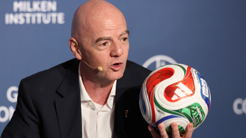 FIFA-Präsident Gianni Infantino hält einen bunten Fußball hoch