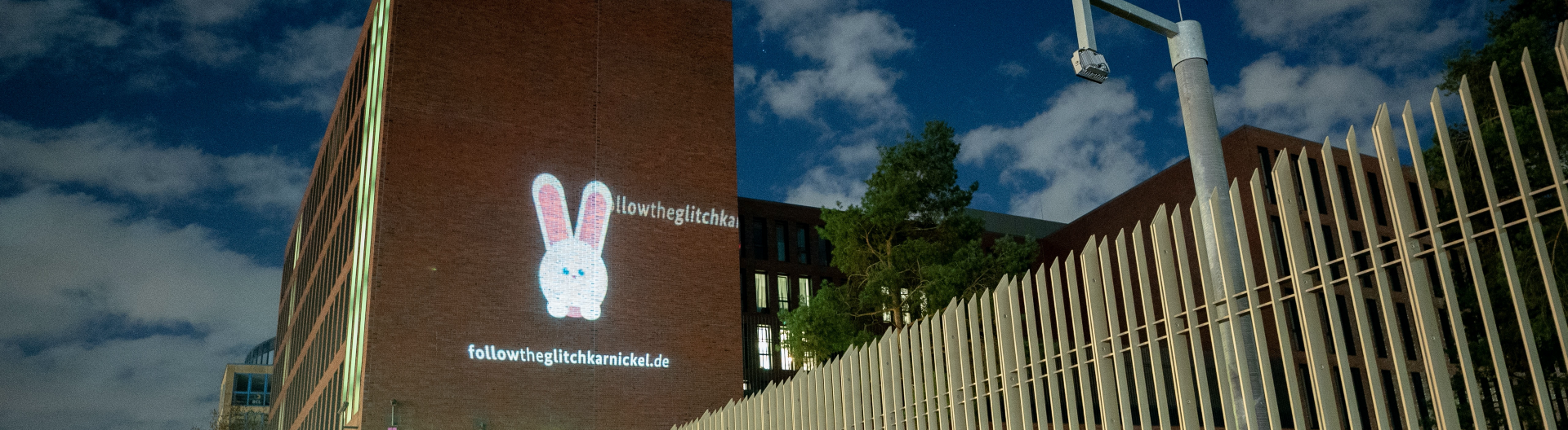 Ein Hase wird auf die Fassade der Zentrale des Bundesnachrichtendienstes (BND) projiziert. Unter dem Hasen ist die Internetadresse "followtheglitchkarnickel.de" zu sehen
