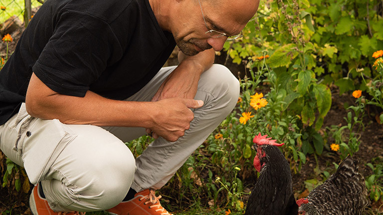 Dirk Gratzel mit einem Huhn.