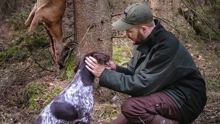 Der Jäger Fabina Grimm mit seinem Jagdhund Kira und einem erlegten Reh.