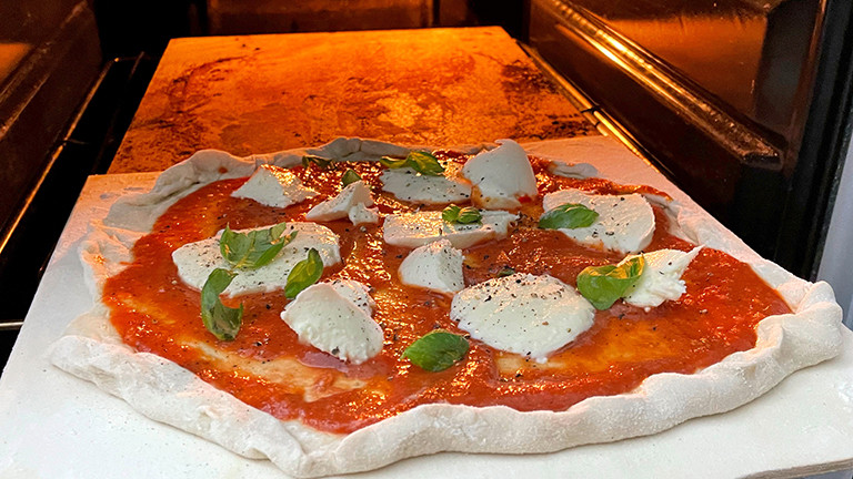 Eine selbstgemachte Tiefkühlpizza wird im Ofen vorgebacken.