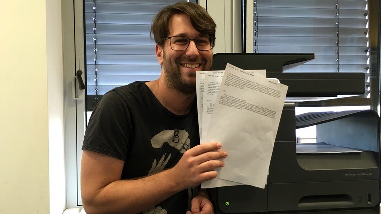 Sebastian Sonntag hält drei Faxe in der Hand