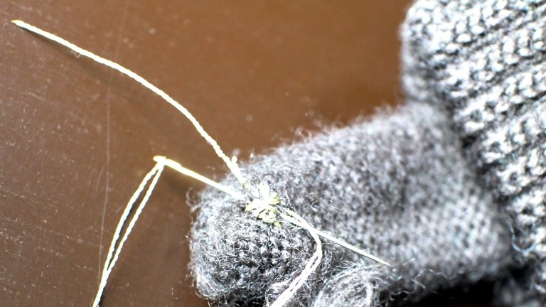 02 Für die ersten Stiche wird der Handschuhfinger umgestülpt, die meisten Stiche macht man danach von außen.