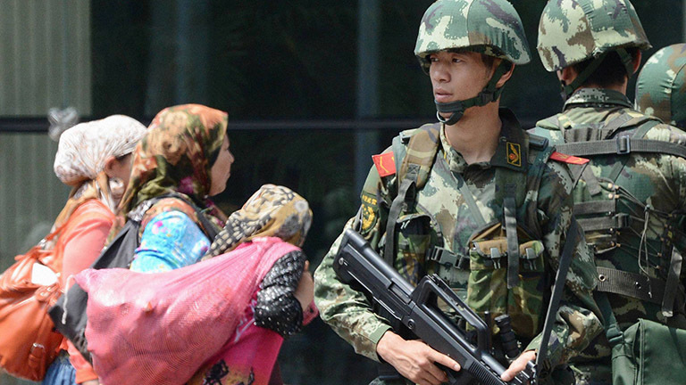 Chinesische Soldaten und uigurische Frauen.