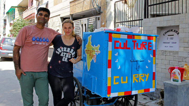 Christina Franzisket und Nagender Chhikara vor einer Motorrikscha mit der Aufschrift "Culture Curry"