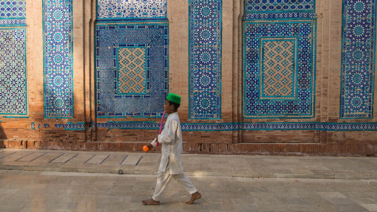 Ein Junge läuft durch eine pakistanische Altstadtgasse.