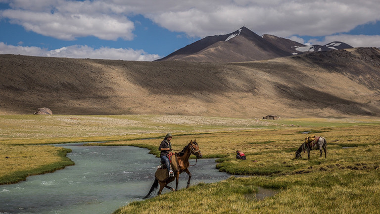Die Fotografin und Autorin reitet auf einem Pferd im Pamir.