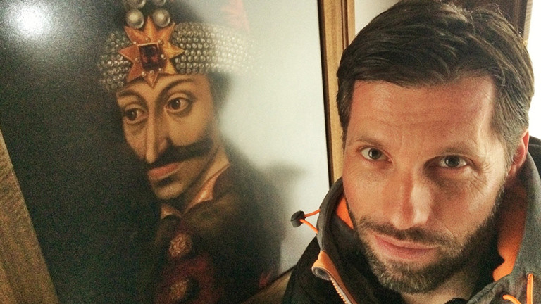 ARD-Korrespondent Till Rüger neben einem Bild von Graf Dracula ARD-Korrespondent Till Rüger Auge in Auge mit dem historischen Vorbild Graf Dracula.