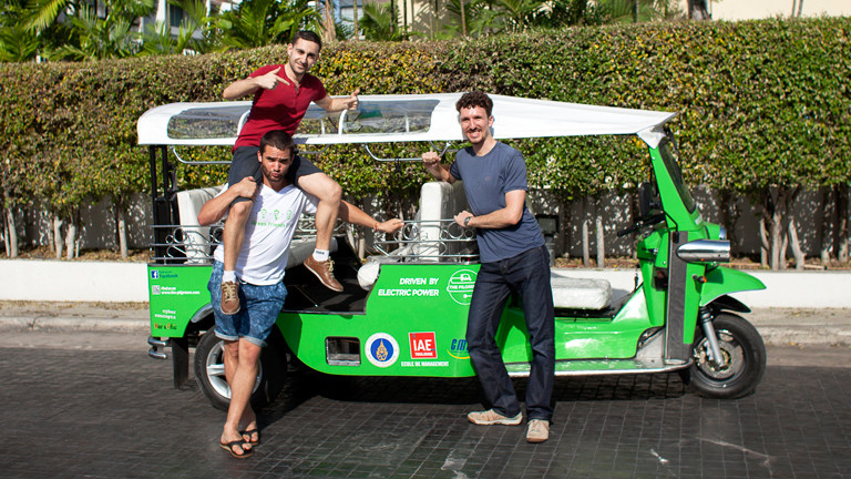 Drei Kungs vor einem grünen Tuk-Tuk