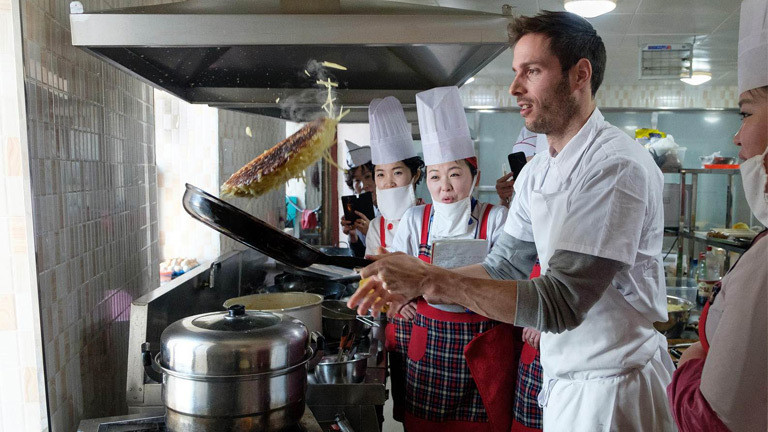 Schweizer Koch Markus Arnold zeigt, wie man ein Rösti in der Pfanne wendet.