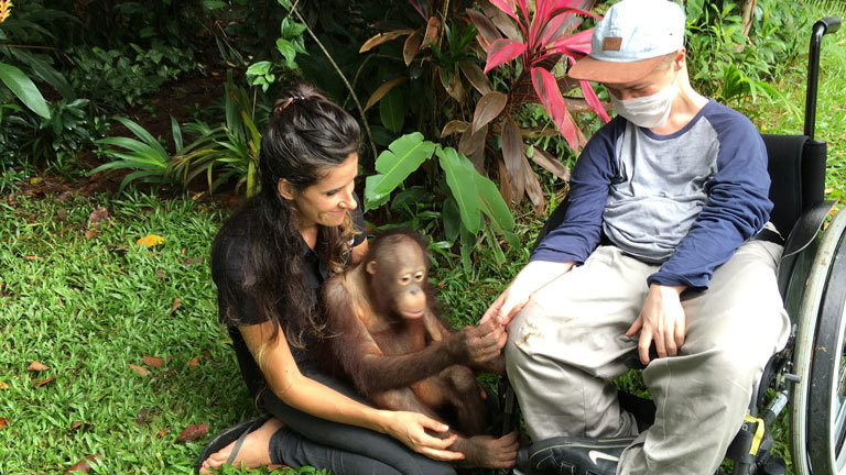 Der Orang-Utan Waise Boy gibt Benni Over die Hand.