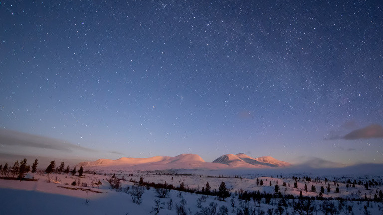 Der aufgehende Mond beleuchtet das Sølenmassiv in Norwegen.