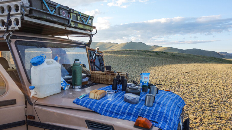 Mongolei: Früjstück auf Haube Auto
