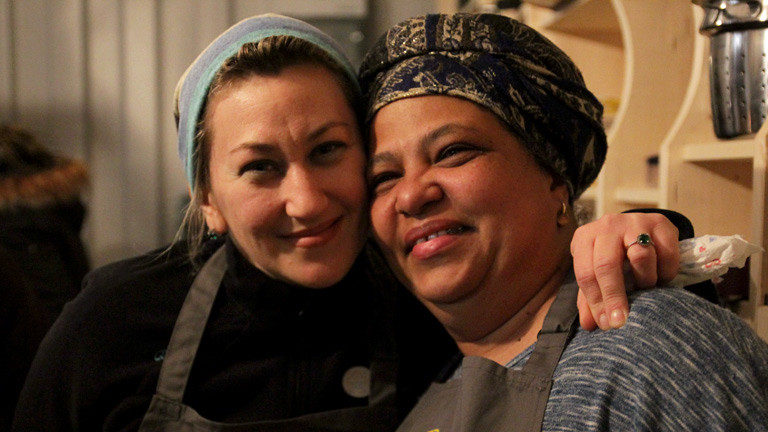 Zwei Helferinnen und Gäste von kitchen on the run