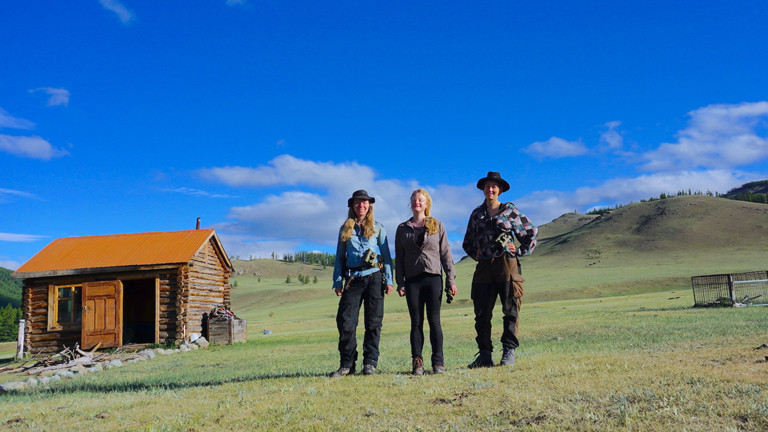 Drei Frauen vor einer Hütte