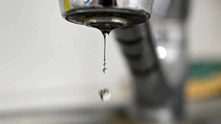 Ein Wassertropfen löst sich aus einem Wasserhahn