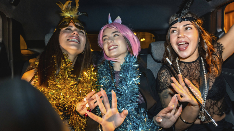 Drei Frauen im Partymodus sitzen in einem Auto