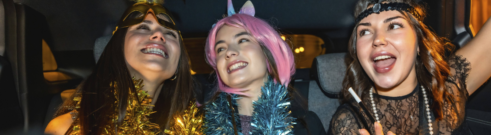 Drei Frauen im Partymodus sitzen in einem Auto