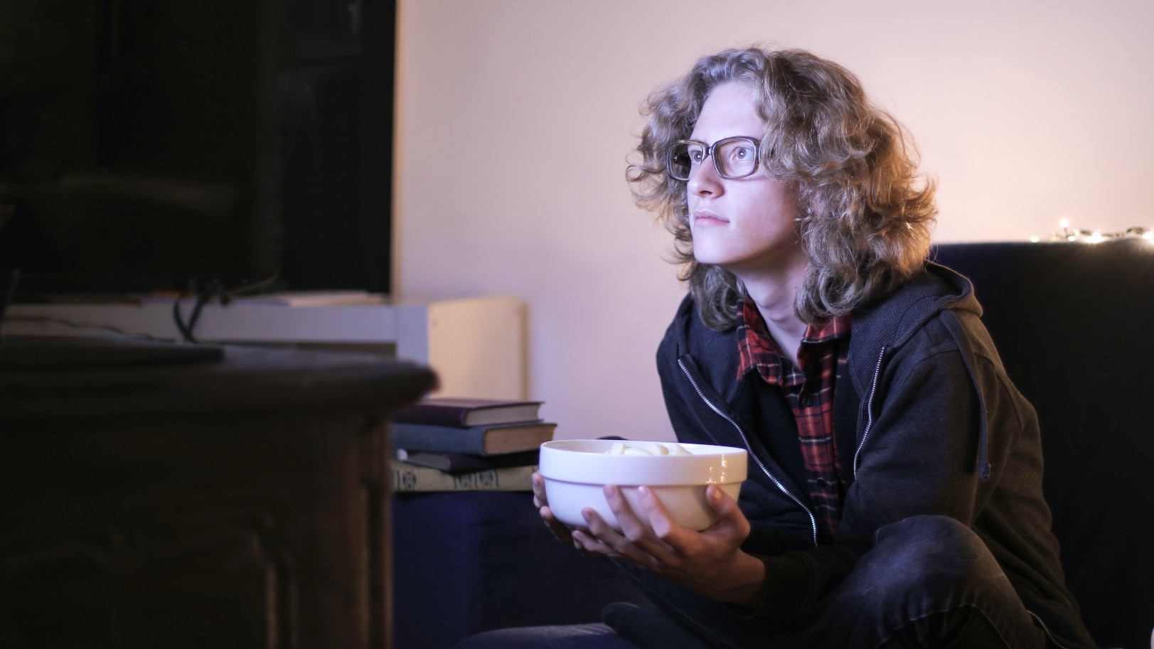 Eine Person sitzt vor einem Fernseher und guckt.