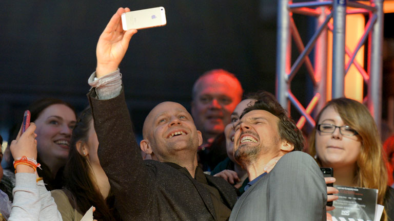 Die Schauspieler Florian David Fitz (r) und Jürgen Vogel fotografieren sich am 26.09.2014 vor der Premiere des Films "Hin und weg" im Rahmen des Hamburger Filmfestes im Cinemaxx Kino in Hamburg mit Fans am roten Teppich.