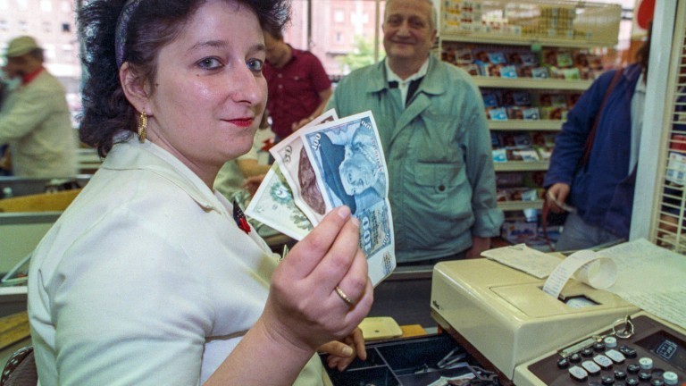Eine Kassiererin mit D-Mark-Einnahmen in Ost-Berlin am ersten Tag nach Einführung der Deutschen Mark im Juli 1990.