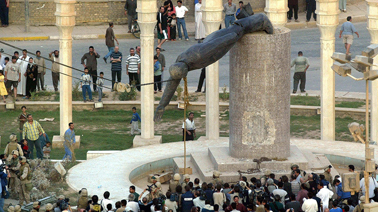 Iraker stehen auf einem Platz in Bagdad und schauen zu, wie die Statue von Diktator Saddam Hussein zu Fall gebracht wird (09.04.2003); Foto: dpa