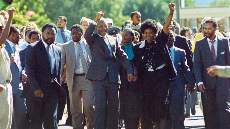 Der wohl berühmteste politische Häftling der Welt, Nelson Mandela und seine Ehefrau Winnie, grüßen mit erhobener Faust am 11.02.1990 nach seiner Freilassung in Paarl die jubelnde Menschenmenge am Wegesrand. .