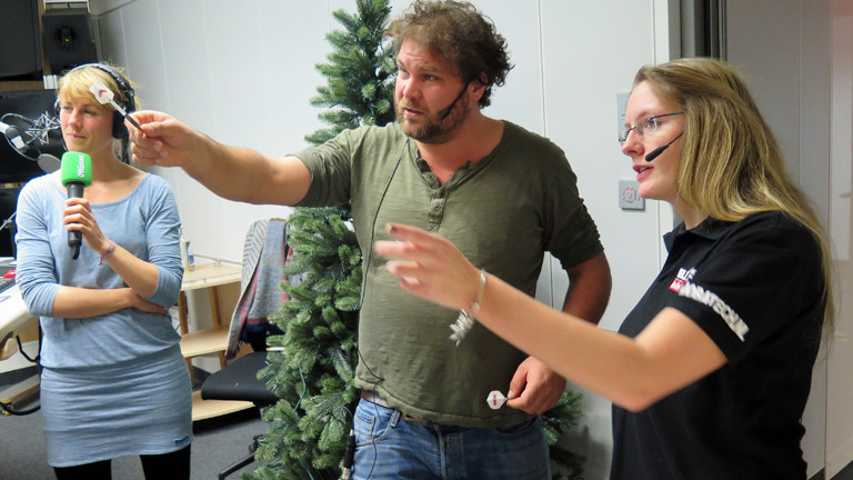 DRadio-Wissen-Moderatoren Paulus Müller und Nora Hespers lassen sich von Dart-Jugendmeisterin Ann-Kathrin Wigmann ihren Sport zeigen.
