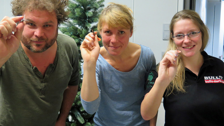 DRadio-Wissen-Moderatoren Paulus Müller und Nora Hespers lassen sich von Dart-Jugendmeisterin Ann-Kathrin Wigmann ihren Sport zeigen.