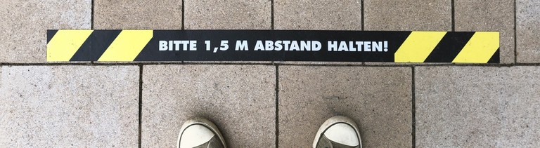 Hinweis zum Abstandhalten auf der Straße.