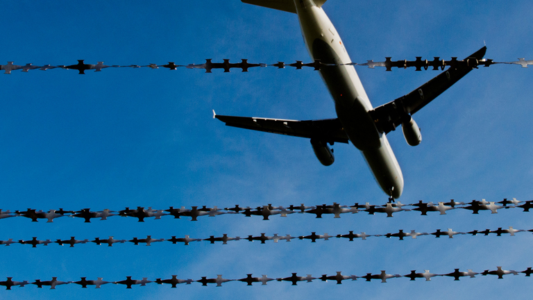 Flugzeugstart am Himmel hinter dem Zaun. dpa