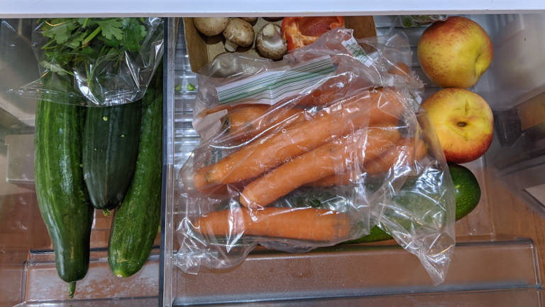 Gurken, Karotten, Äpfel in einer Kühlschrank-Schublade