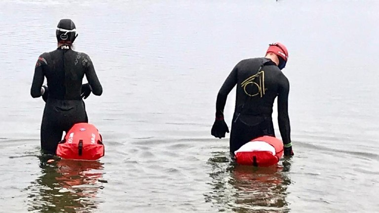 Tobias Oelmaier mit seiner rot-orangenen Boje und Schwimmbegleitung.