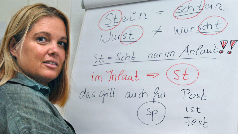 Die Sprecherzieherin Ariane Willikonsky zeigt auf einer Tafel den Unterschied zwischen schwäbischem Dialekt und Hochdeutsch; Bild: dpa
