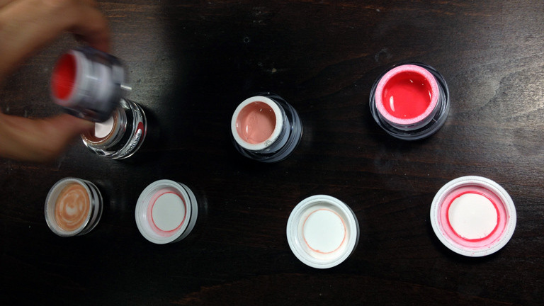 Dena begutachtet die verschiedenen Trendfarben wie Koralle und Rosé im Nagelstudio von Alex Schneider.