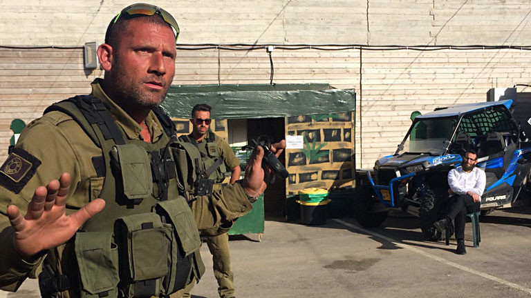 Ein Mann steht in einer Militäruniform auf einem Schießgelände