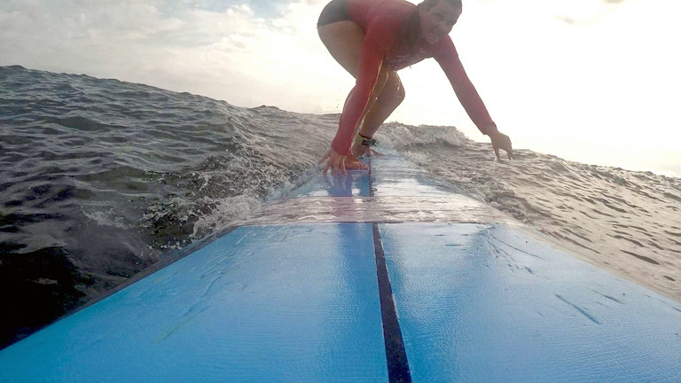 Caro probiert Surfen aus. Ihr Lieblingssport aus diesem Monat